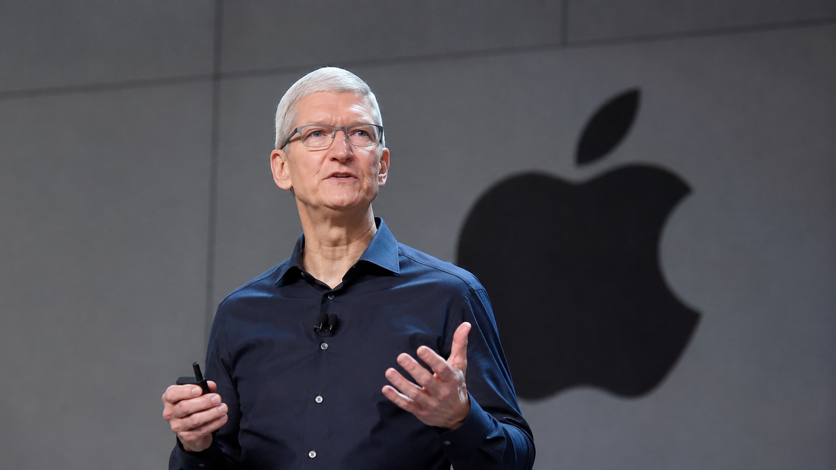 Tim Cook speaking in front of an Apple logo